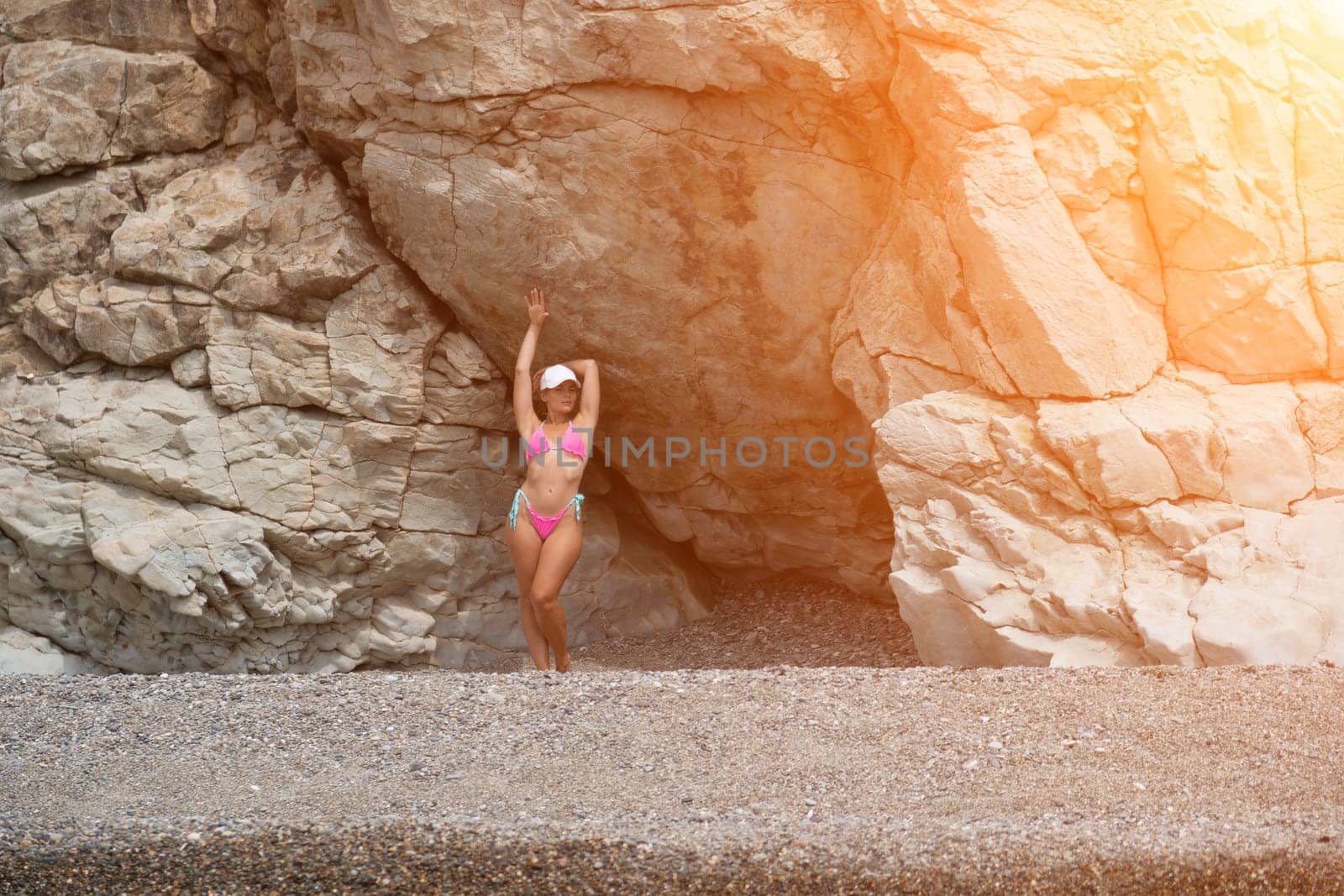 Woman travel sea. Happy tourist in pink bikini enjoy taking picture outdoors for memories. Woman traveler posing on the beach at sea surrounded by volcanic mountains, sharing travel adventure journey by panophotograph