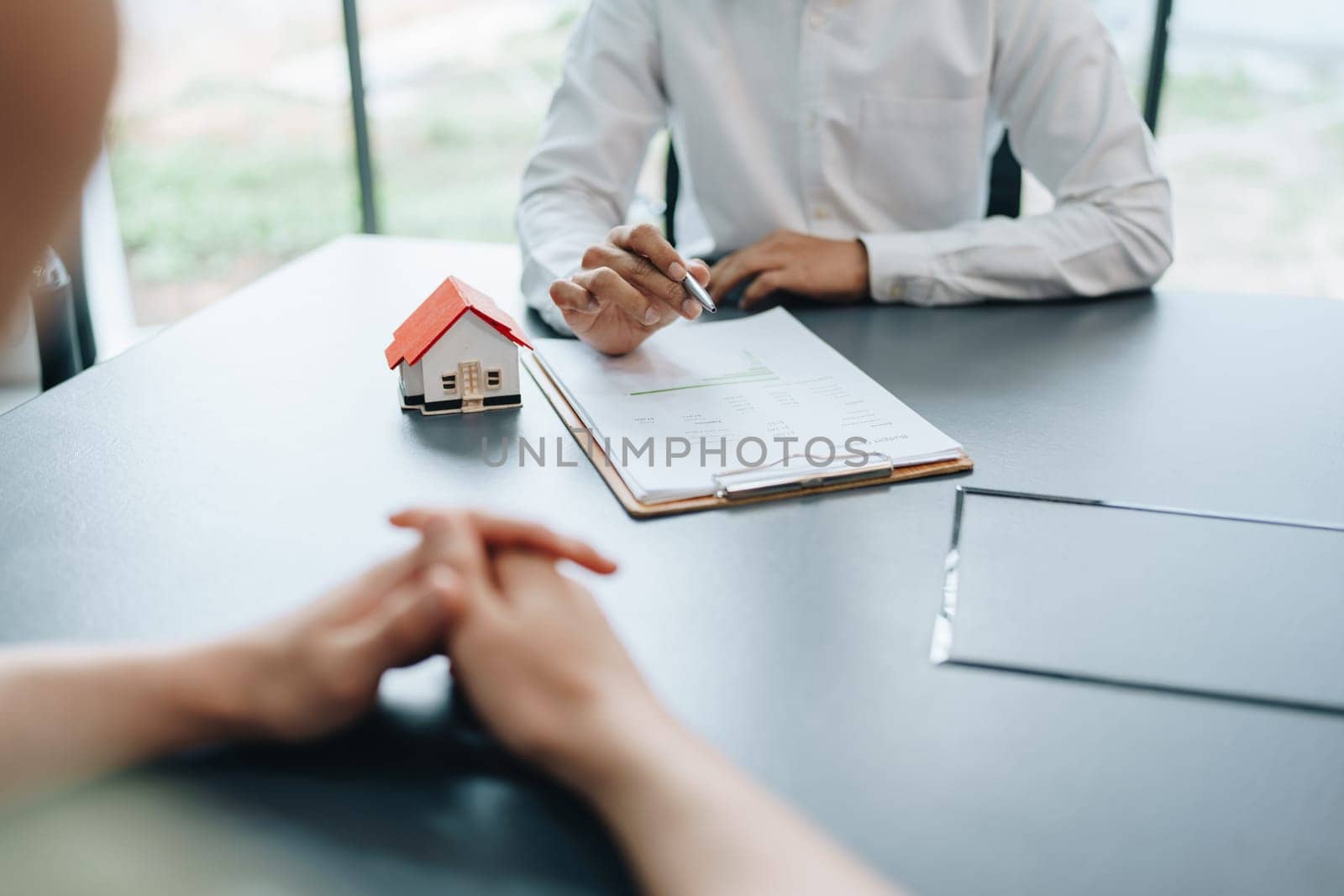 Guarantee, mortgage, agreement, contract, signed, real estate agent pointing to documents for customers to read the agreement before signing important documents.