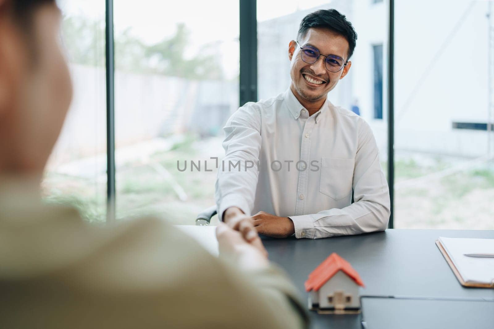 Guarantee, mortgage, agreement, contract, signed, real estate agent pointing to documents for customers to read the agreement before signing important documents.