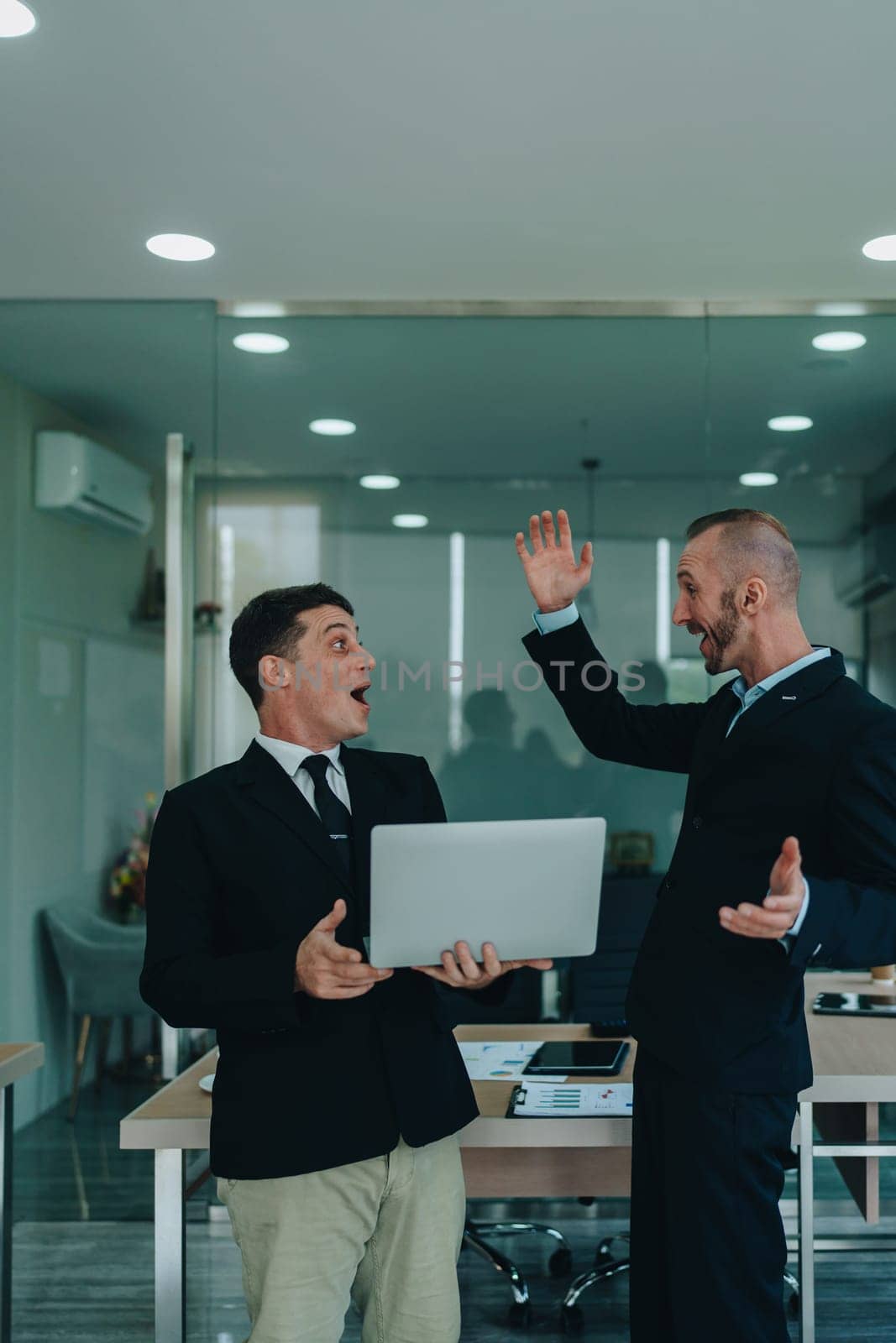 Give me five. managers employees join hands high celebrate common achievement. Two young men successful teammates friends greet each other with great job result by Manastrong