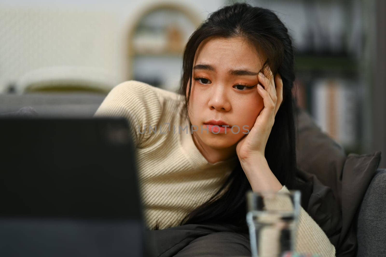 Sick young woman covered with blanket having online consultation with doctor on laptop.Telemedicine and healthcare concept.