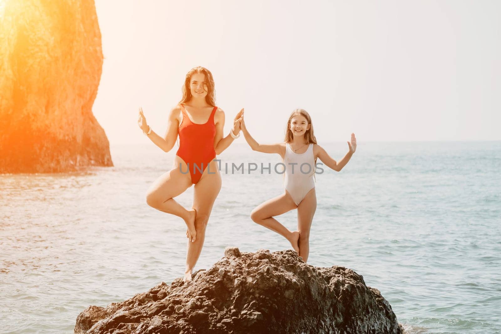 Silhouette mother and daughter doing yoga at beach. Woman on yoga mat in beach meditation, mental health training or mind wellness by ocean, sea