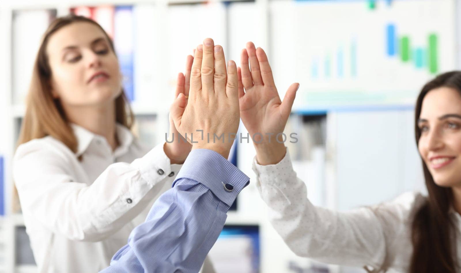 Focus on female and male hands demonstrating greeting gesture and posing at modern workplace. Businesspeople celebrating signing profitable contract. Friendly teamwork concept