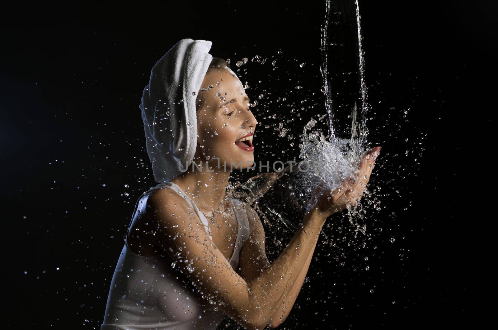 Happy girl washing her face isolated cropped shot on black background