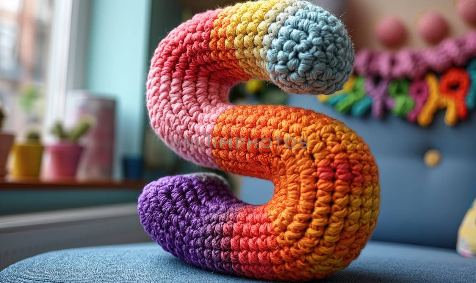 Knitted colored letter S on an abstract background. Selective focus.