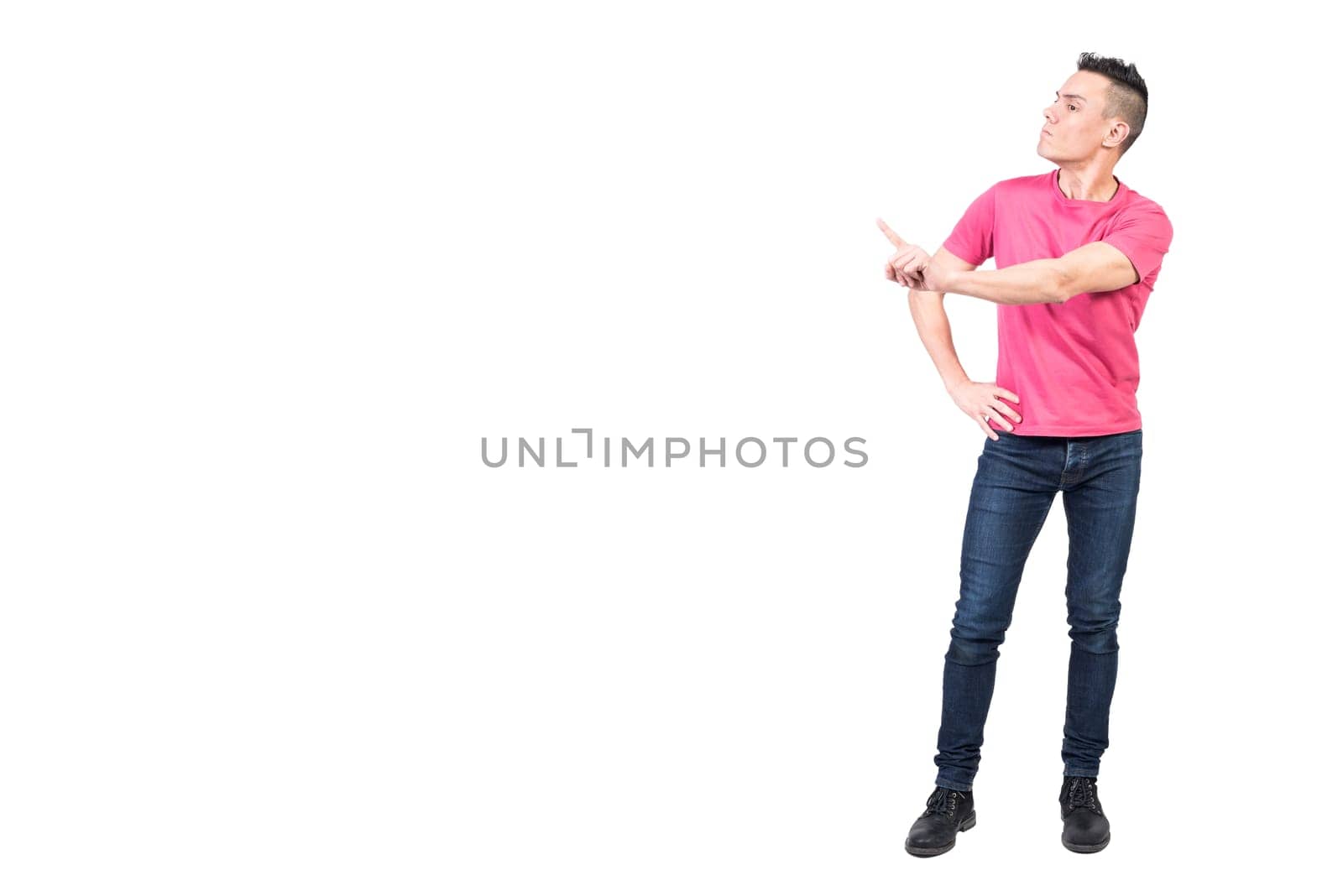 Full body of serious male model standing with hand on waist and showing reject gesture while scolding and expressing bad attitude on white background