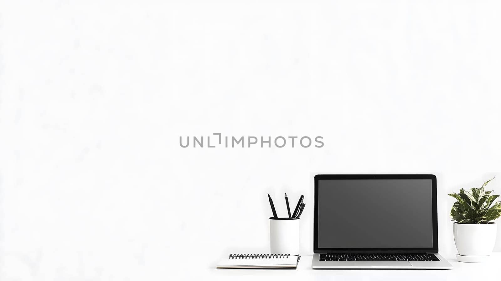 Clean and organized workspace is waiting for a productive day featuring a laptop, a notebook and a pen holder