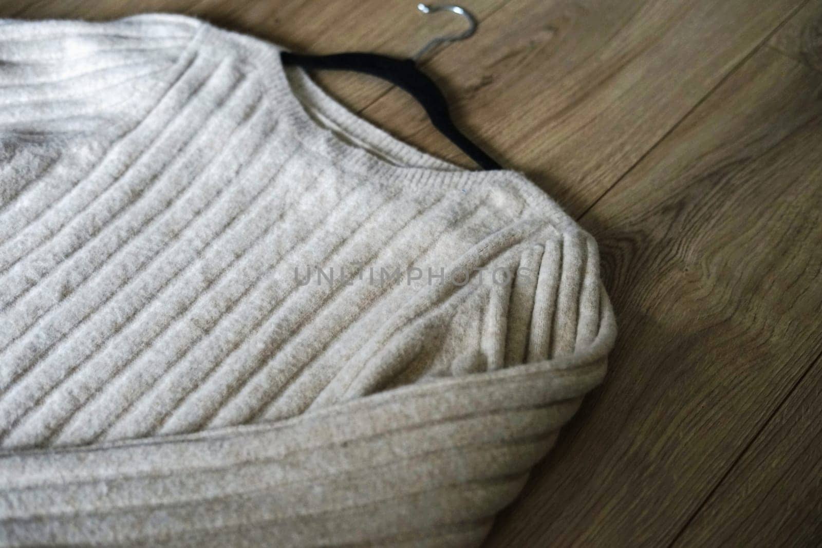 winter cozy woolen beige sweater on wooden floor winter cold season christmas new year home . High quality photo