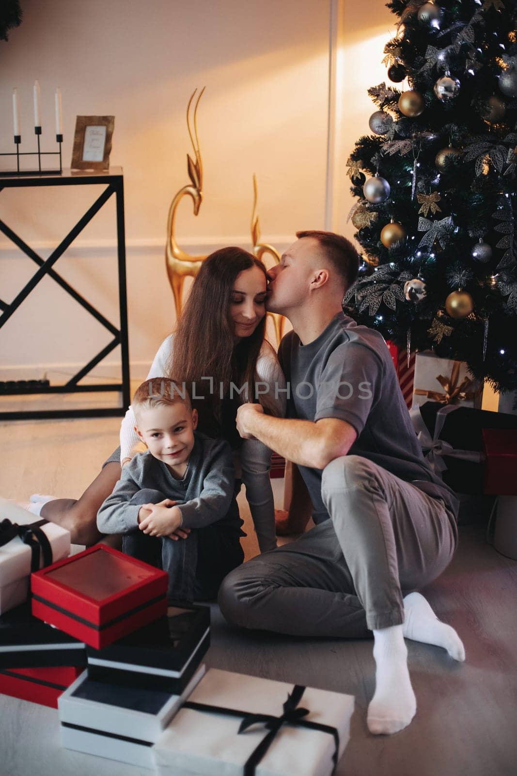 A family around the Christmas tree in the new year, a holiday with family,a beautiful happy stylish family.