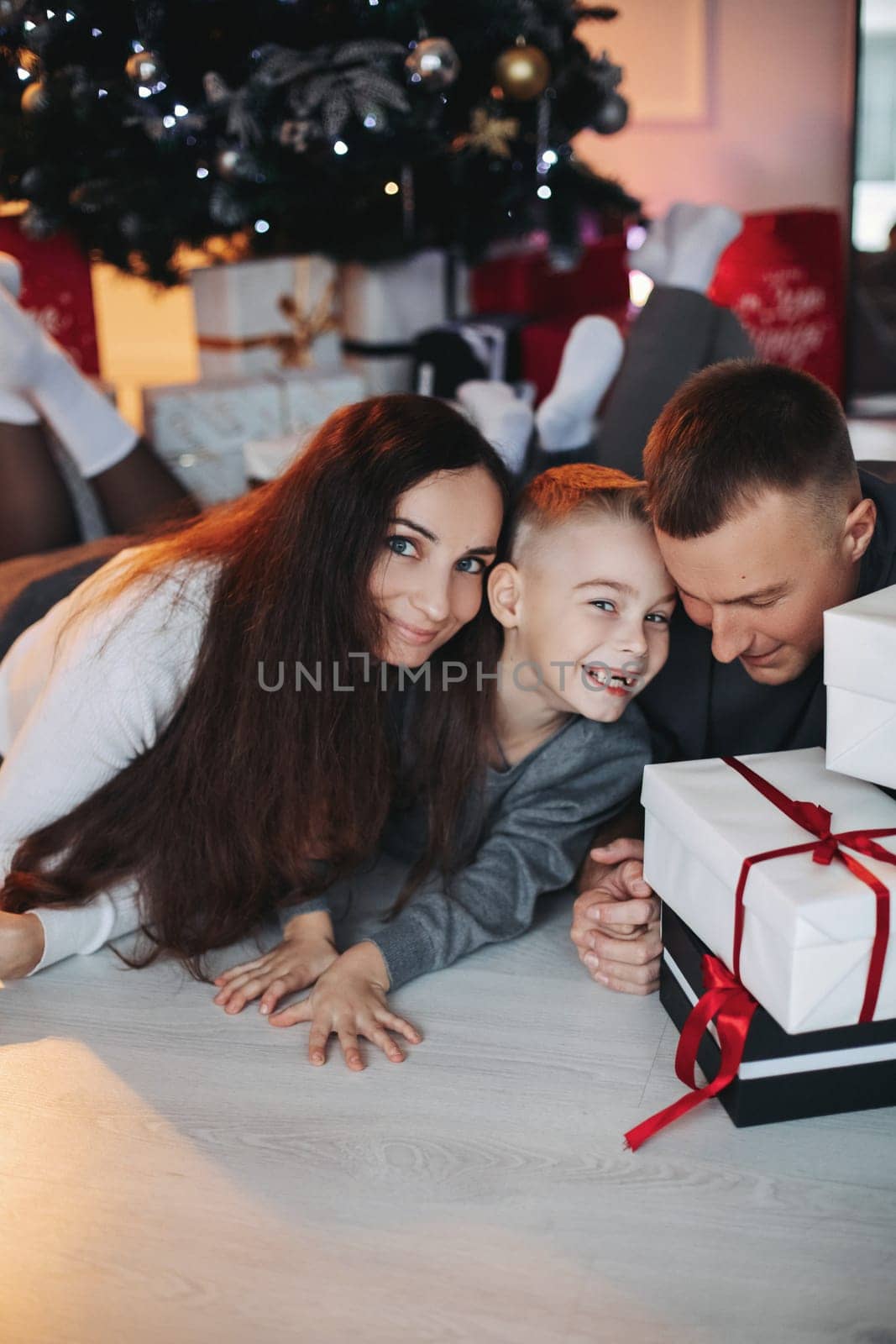 A family around the Christmas tree in the new year, a holiday with family,a beautiful happy stylish family.