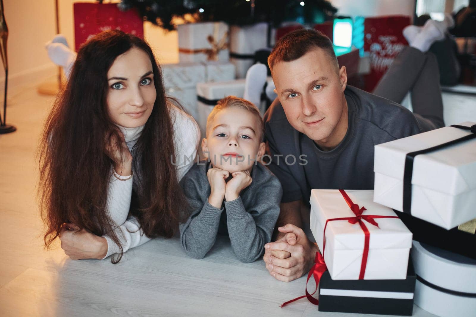 A family around the Christmas tree in the new year, a holiday with family,a beautiful happy stylish family.