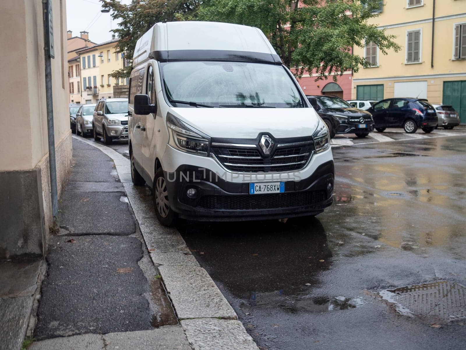 Cremona, Lombardy, Italy October 15th 2024 White renault trafic camper van parked on the side of a wet street in a residential area after the rain