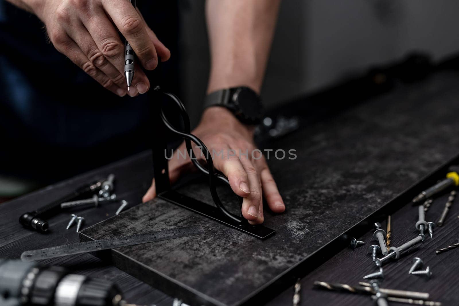 Man Makes Shelf From Board And Bracket For Attaching Hand In Close-Up