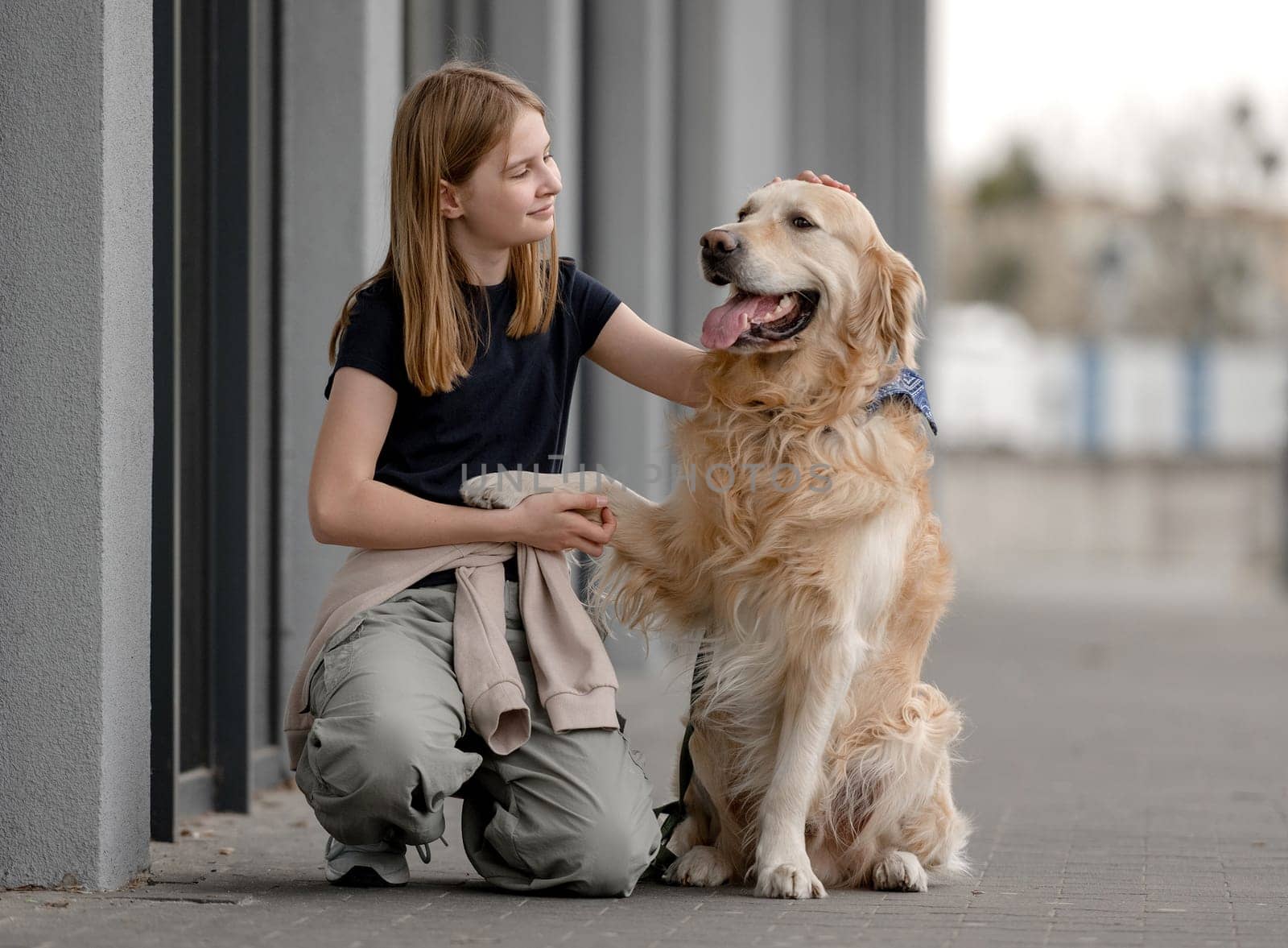 Girl With Golden Retriever Sits Playing Outside