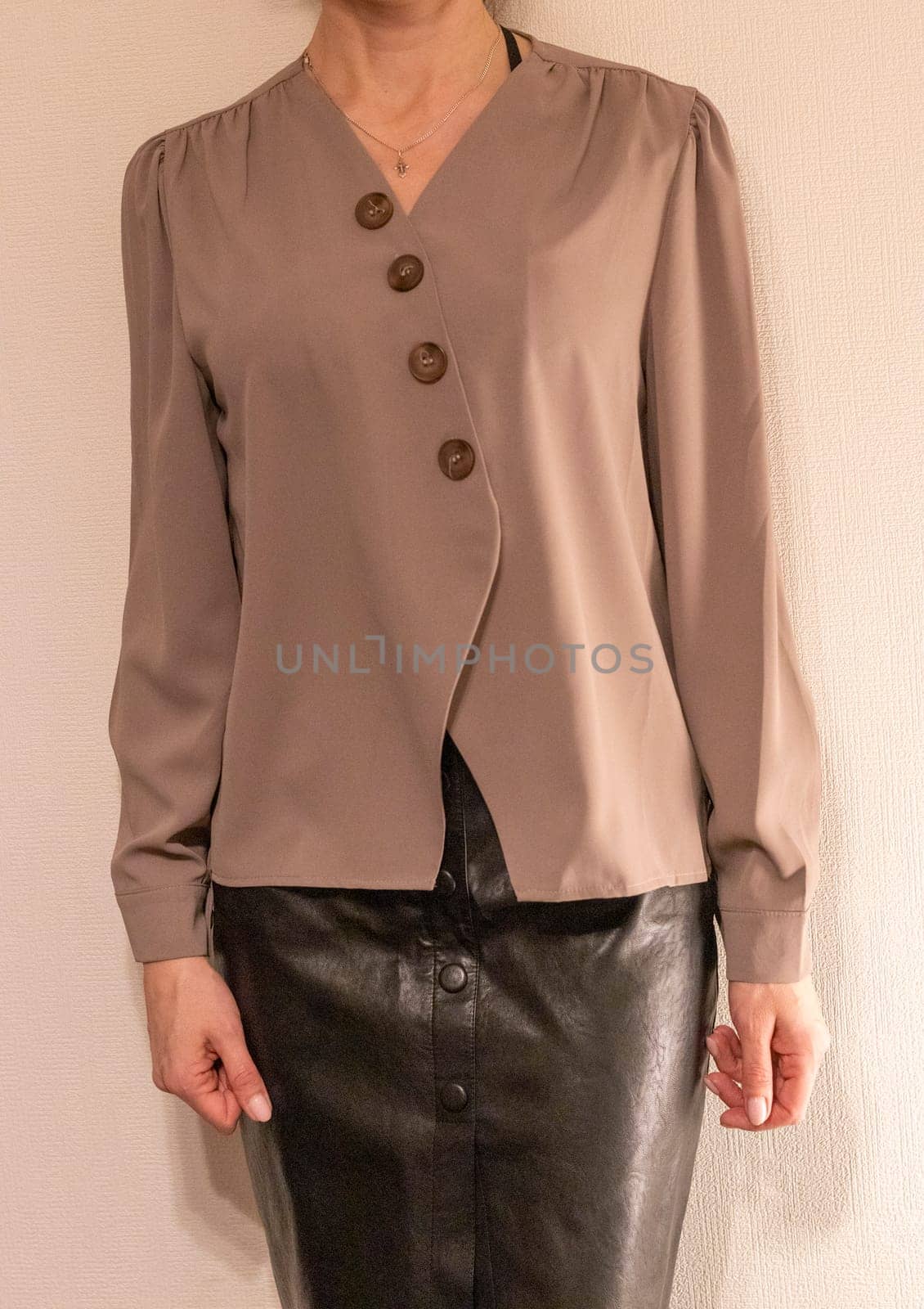 Skinny woman wearing stylish leather tight skirt and warm tone blouse