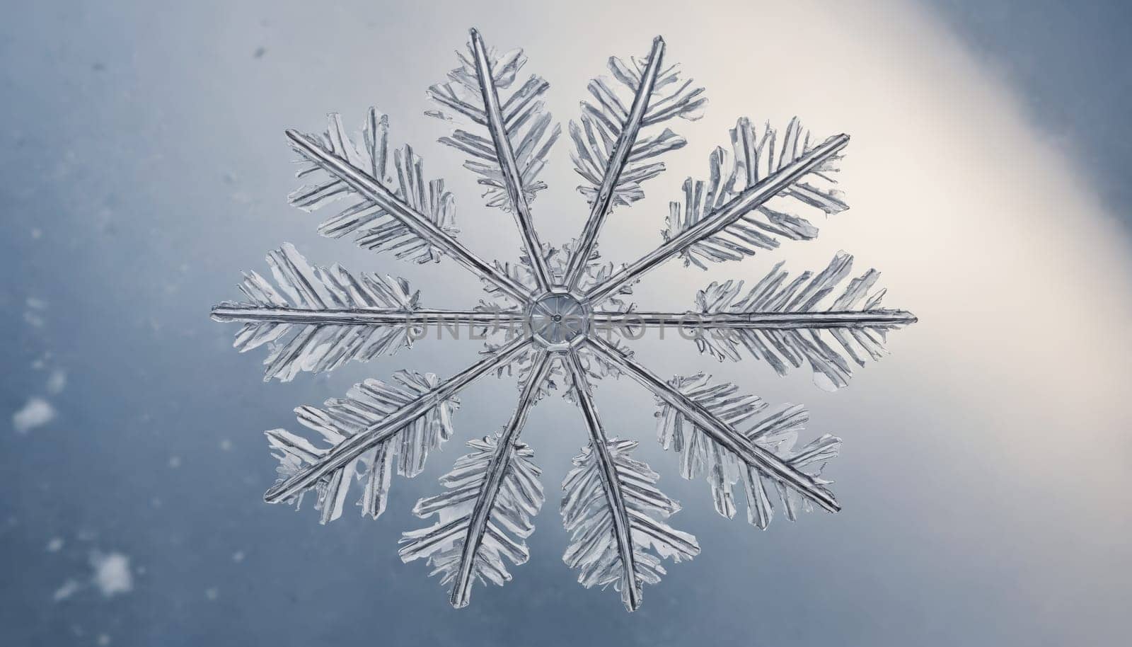 A stunning snowflake exhibits intricate patterns as it sparkles in the soft light of winter. The cool blue backdrop enhances its delicate beauty, capturing a serene moment.