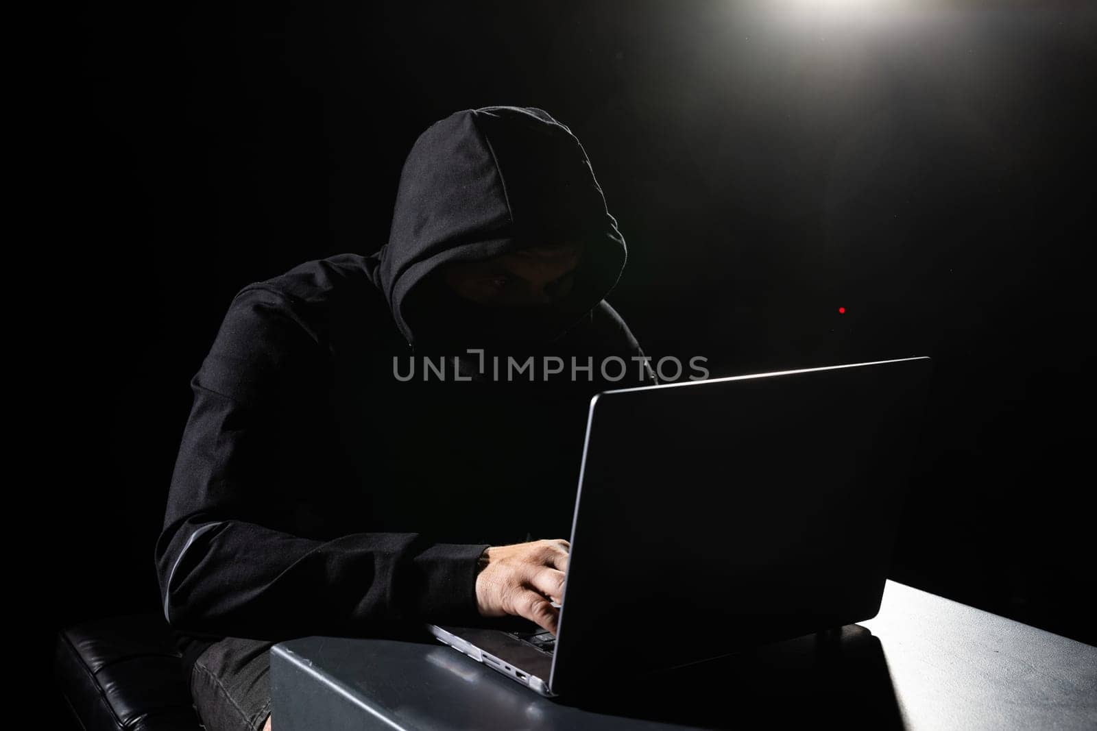 Computer Hacker in Hoodie. Obscured Dark Face. Hacker Attack, Virus Infected Software, Dark Web and Cyber Security Concept .