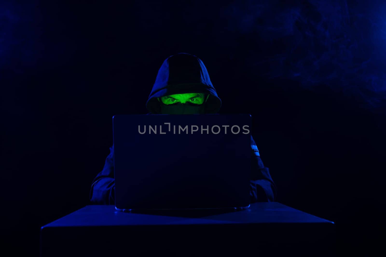 Computer Hacker in Hoodie. Obscured Dark Face. Hacker Attack, Virus Infected Software, Dark Web and Cyber Security Concept .