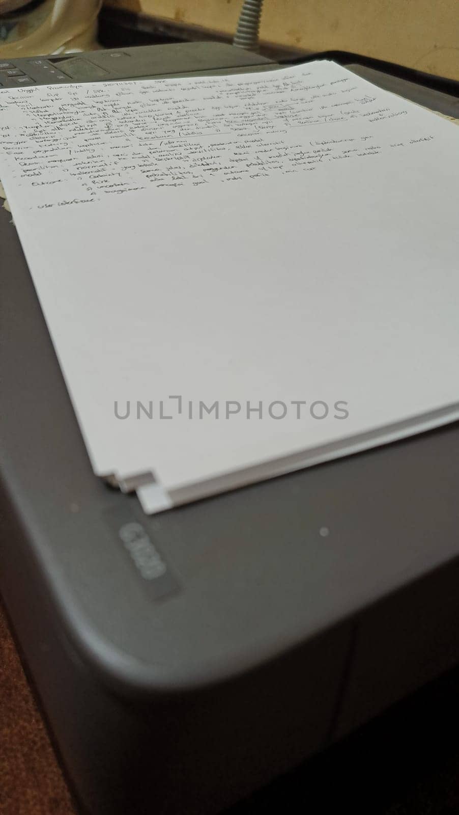 Close-up of a stack of printed papers resting on an office printer tray, highlighting everyday office tasks and technology. Suitable for illustrations about printing, office work, and document management.