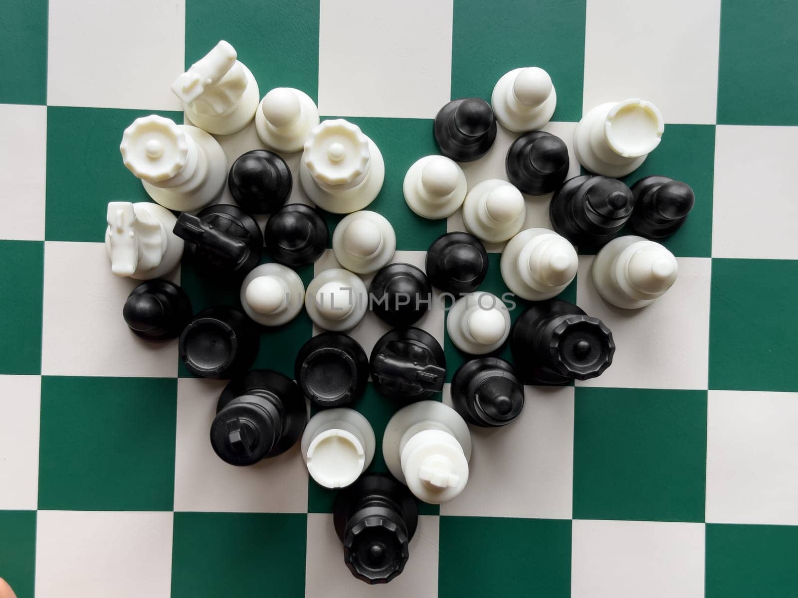Chess pieces clustered on green and white checkerboard.