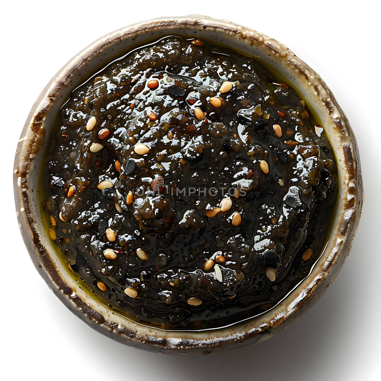 A traditional Asian dish featuring a bowl of black sauce topped with sesame seeds, a common ingredient used in cuisine for added flavor and texture