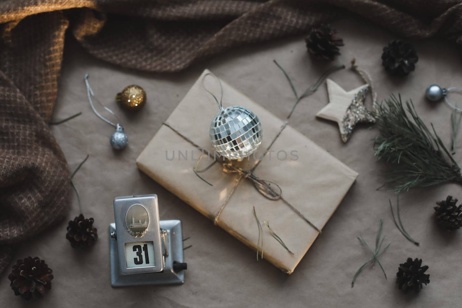 Christmas composition. Gift, fir tree branches, balls on craft paper background. Christmas, winter, new year concept. Flat lay, top view, copy space.