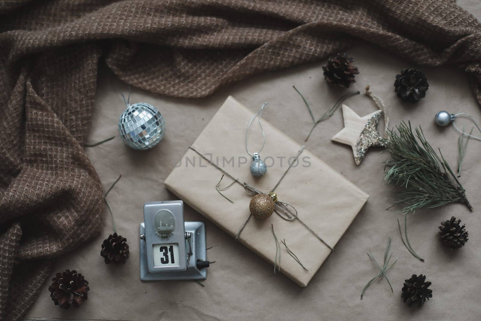 Christmas composition. Gift, fir tree branches, balls on craft paper background. Christmas, winter, new year concept. Flat lay, top view, copy space.