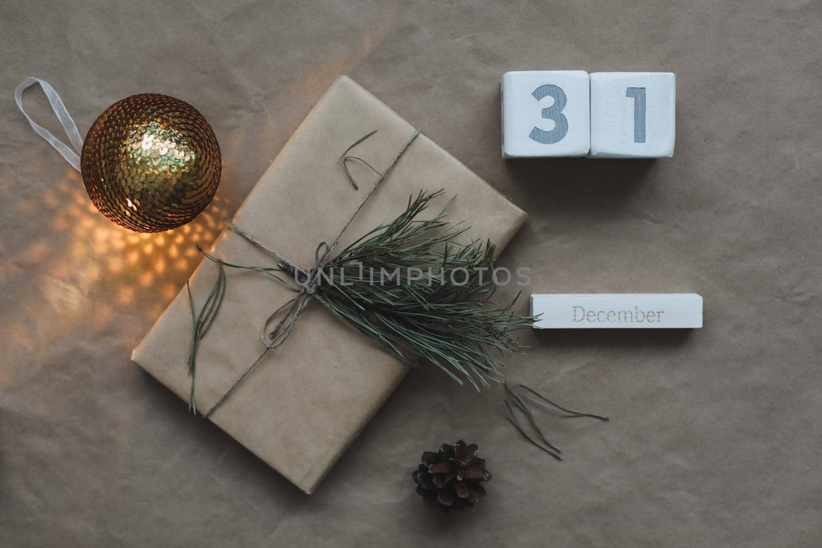Christmas composition. Gift, fir tree branches, balls on craft paper background. Christmas, winter, new year concept. Flat lay, top view, copy space.