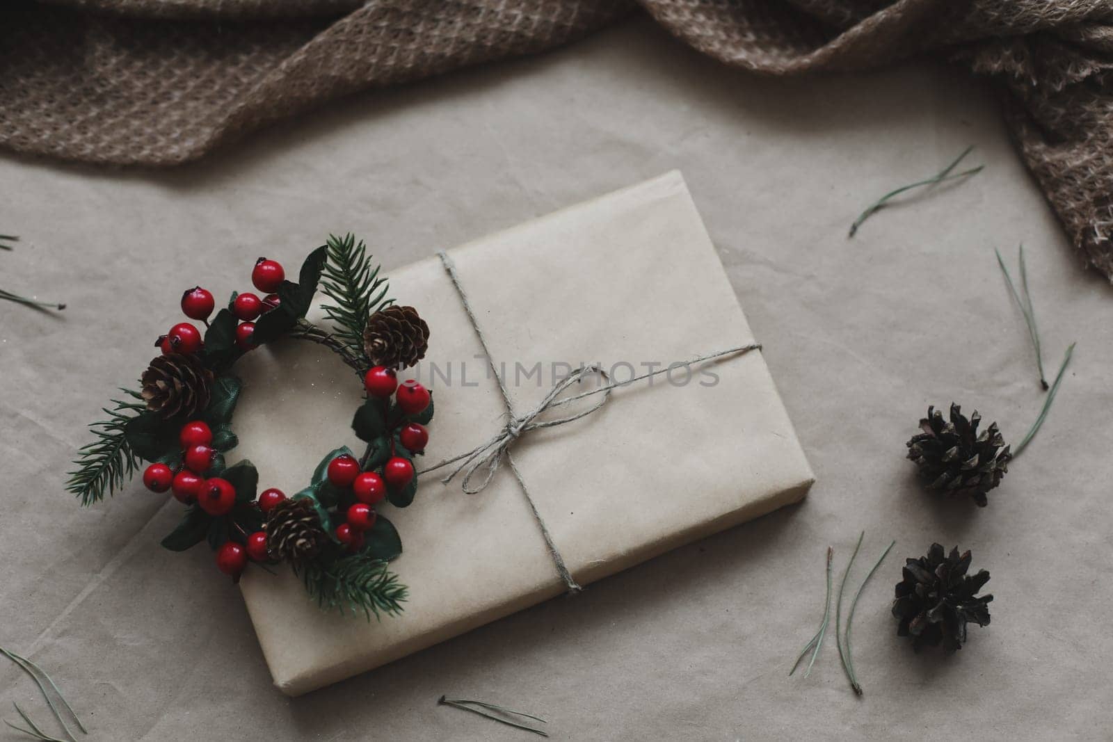 Christmas composition. Gift, fir tree branches, balls on craft paper background. Christmas, winter, new year concept. Flat lay, top view, copy space.