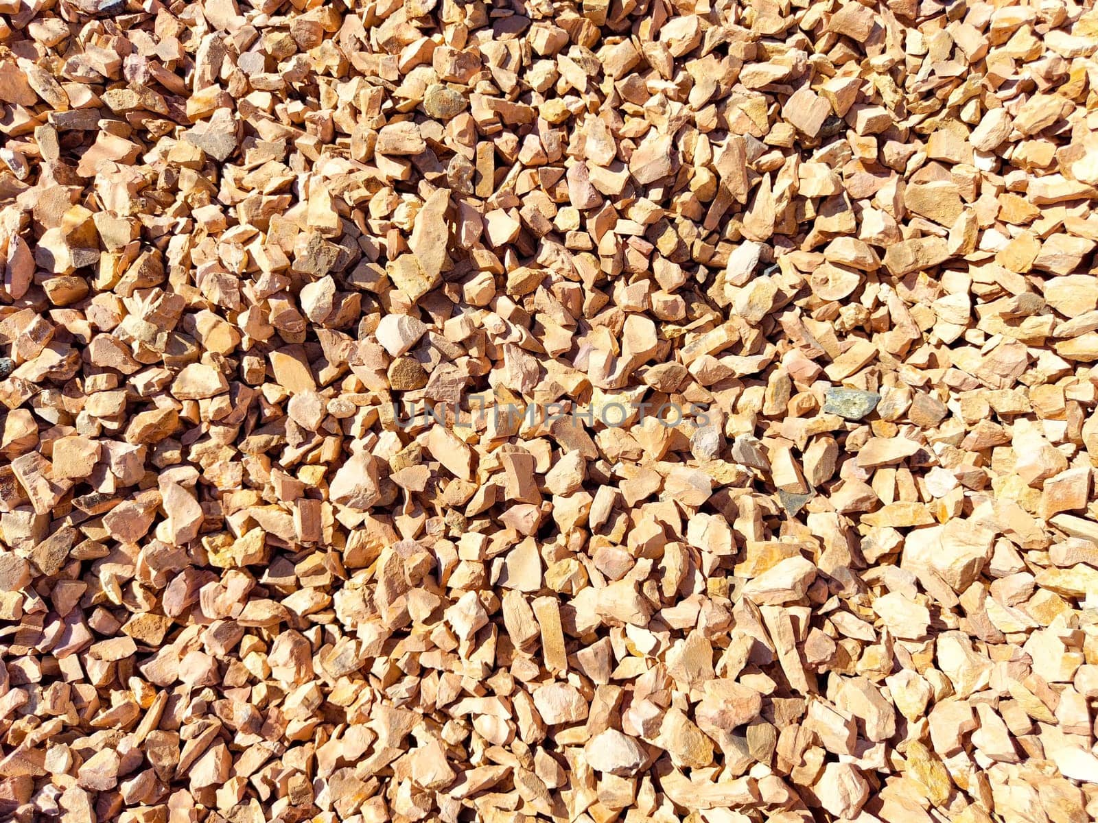 Small, colorful gravel stones cover the ground at a construction location under clear blue skies. background, texture, pattern, frame, place for text