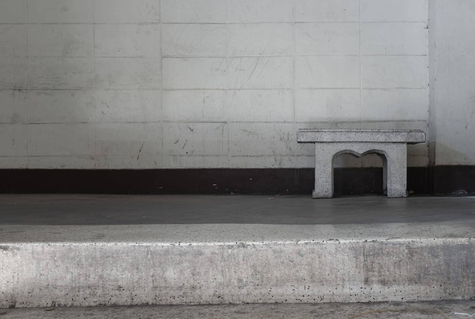 Old concrete texture wall with a old marble bench in front of it. Space for text, Selective Focus.