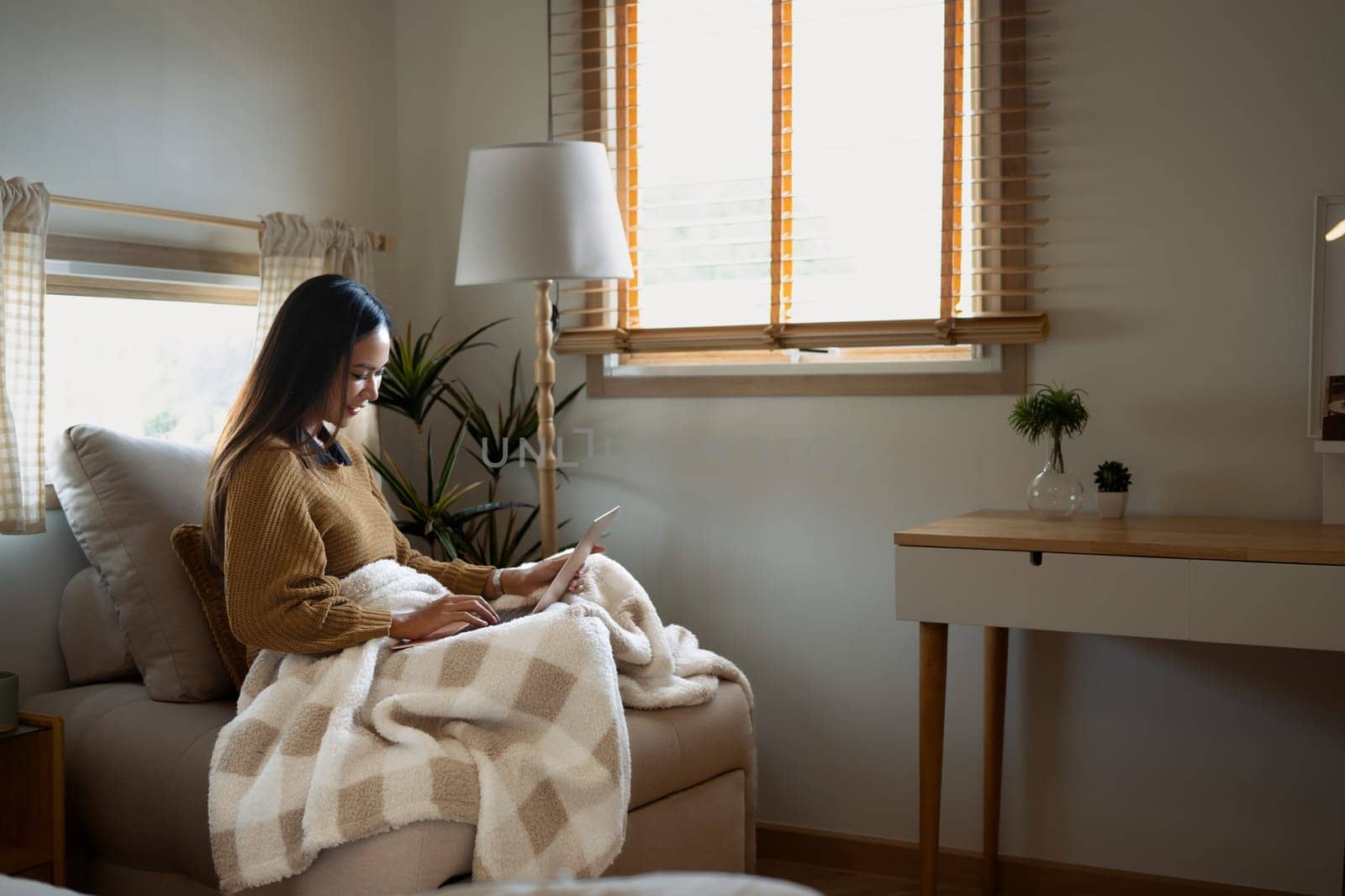 Young woman enjoying work from home in a warm and cozy space.