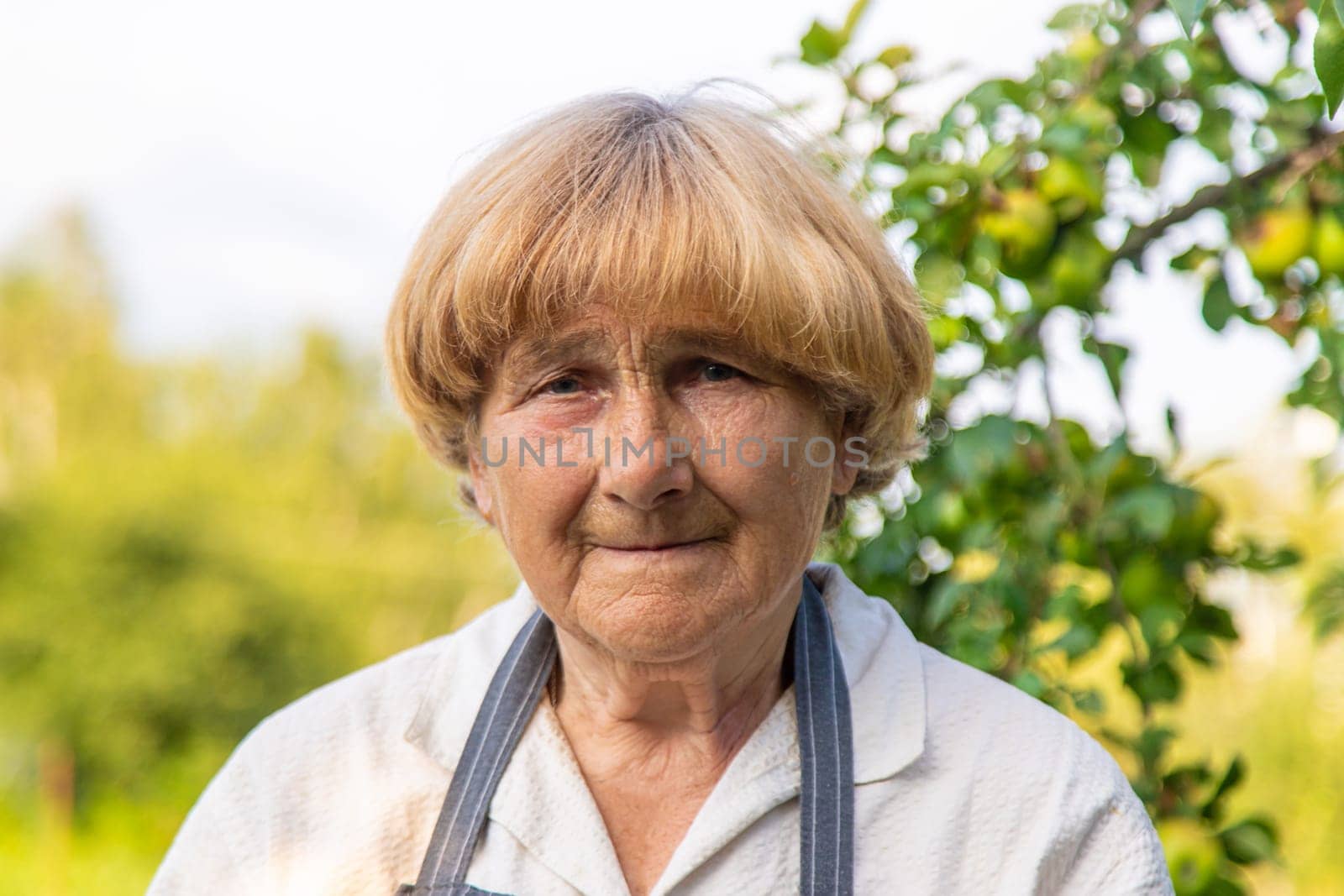 Portrait of an old woman in a garden. Selective focus.. Selective focus. nature.