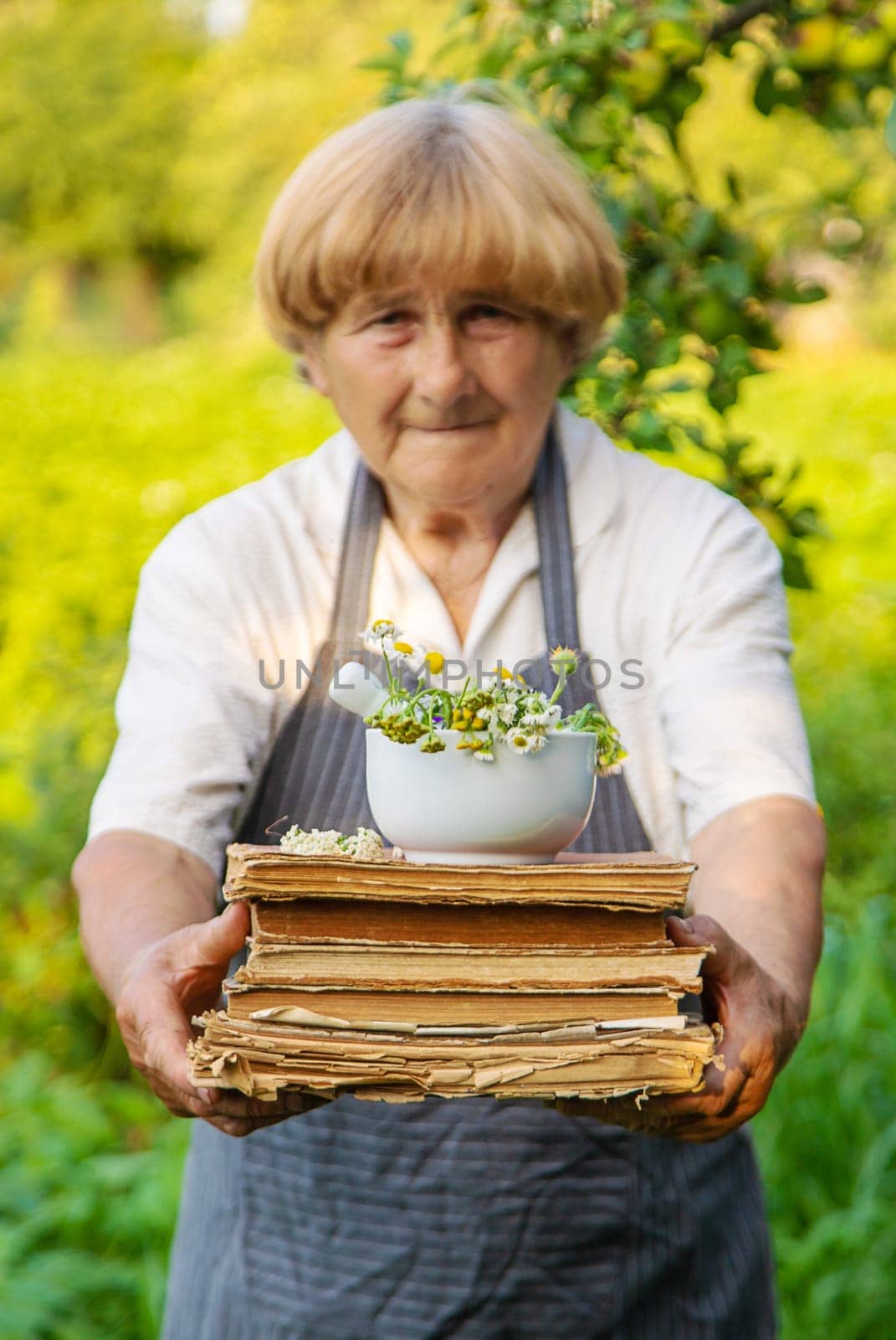 Woman with medicinal herbs in a meadow. Selective focus. nature.