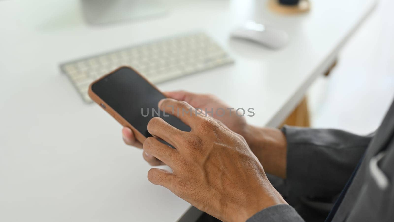 Close up shot of businessman holding mobile phone with white empty display.