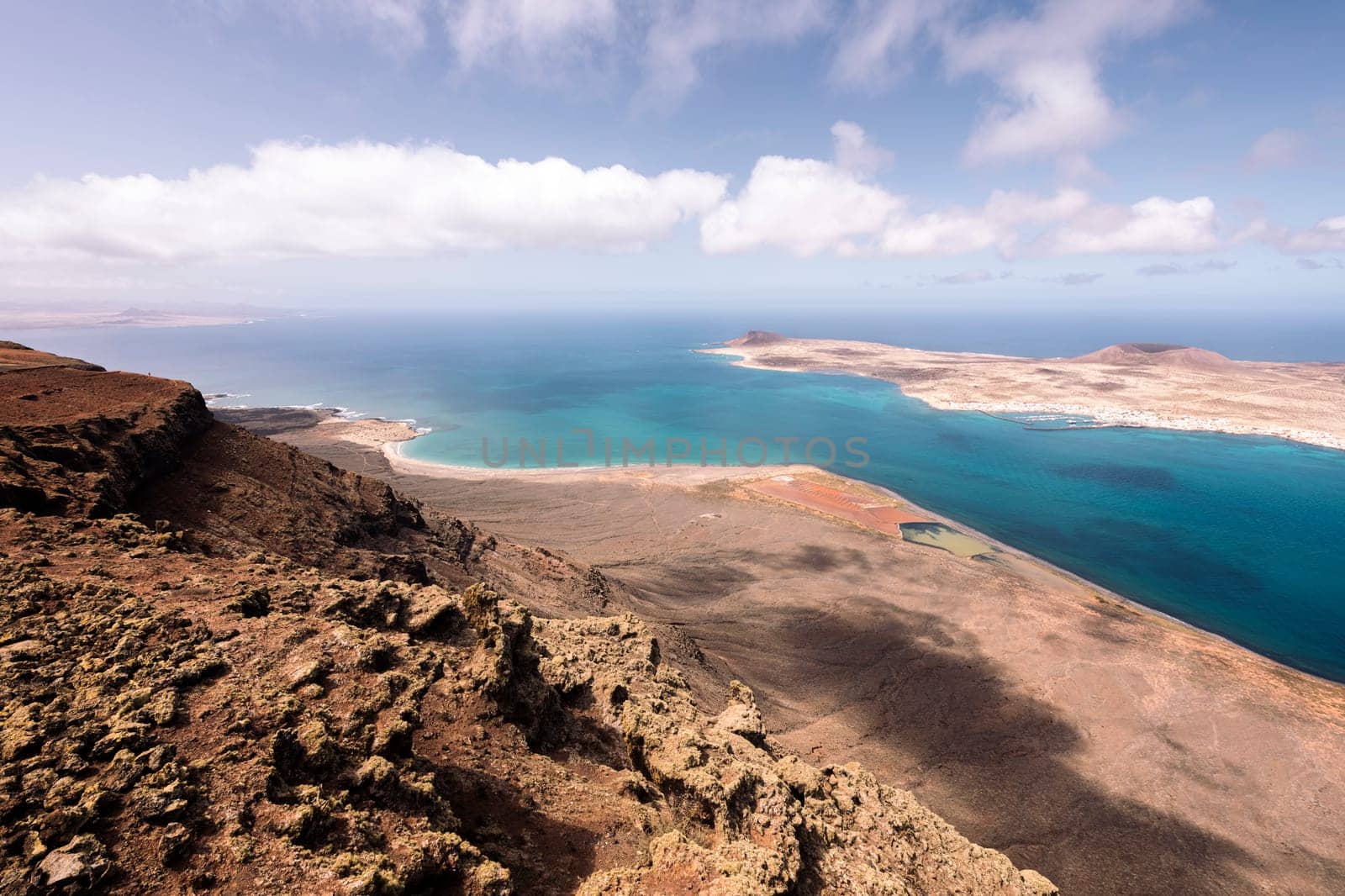 panoramic view of Graciosa Island with volcanic mounts at sundown in sea at Teguise, Lanzarote in Canary Islands, Spain, concept of nature and marine lifestyle