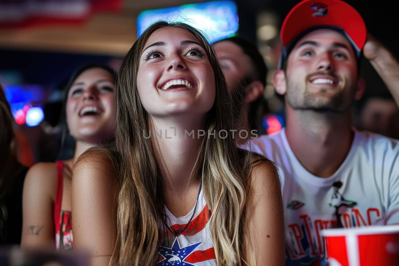 A group of people are watching a baseball game and one woman is smiling. Scene is happy and excited
