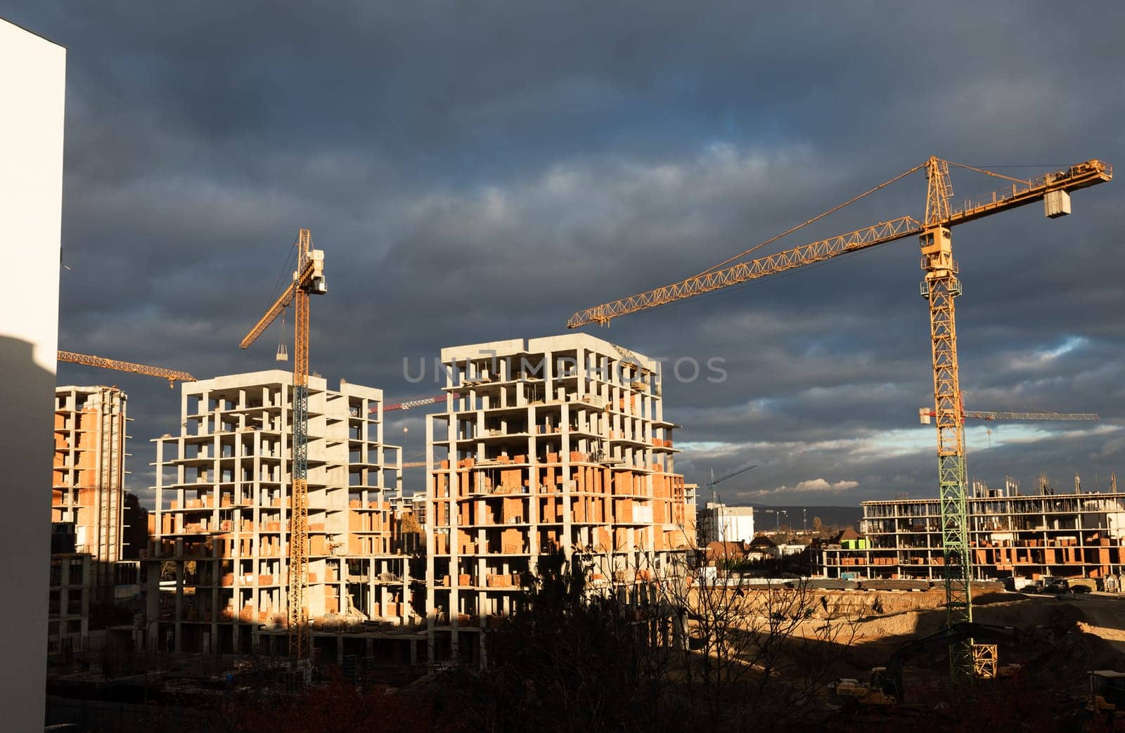 Construction boom in western Ukraine. Several cranes work on multi-story buildings on a large construction site.