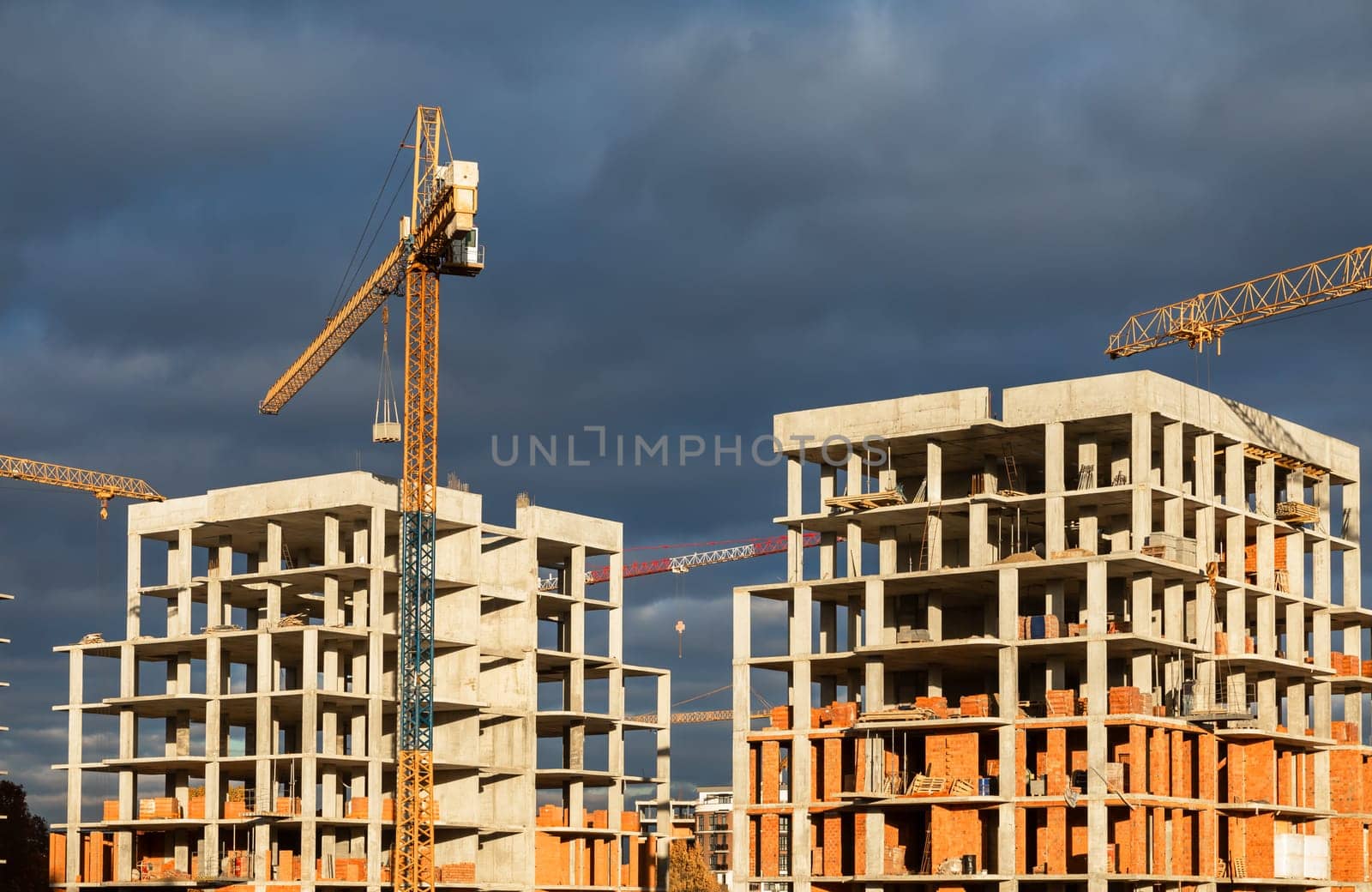 Construction boom in western Ukraine. Urban construction site with cranes against a cloudy sky.