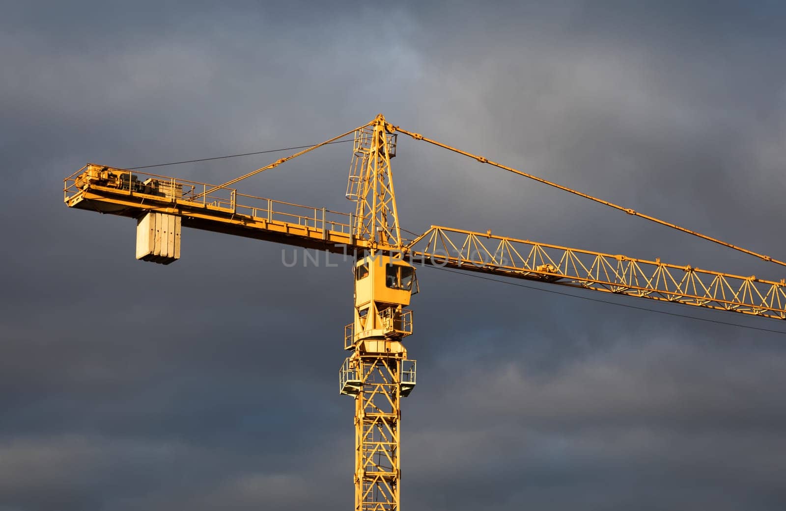 Construction boom in western Ukraine. Sunset light highlights crane and buildings in a city under development.