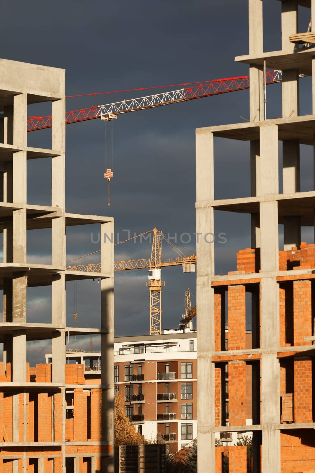 Construction boom in western Ukraine. High-rise buildings under construction, featuring unfinished concrete and brick structures.