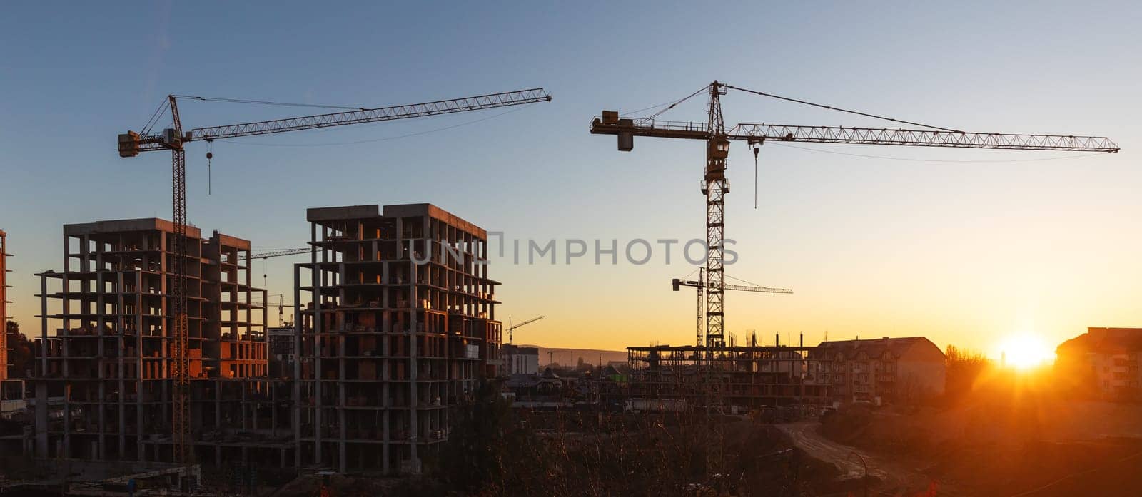 Construction boom in western Ukraine. A construction crane silhouetted against the warm glow of an early morning sky.