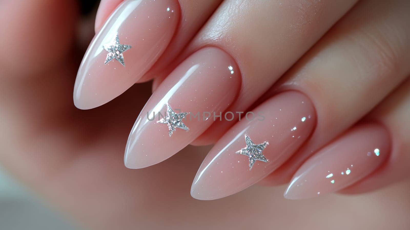 Close-up of a woman's hand showcasing blush pink nail art adorned with sparkling star accents. ideal for beauty, fashion, or design projects creativity and elegance in manicure trends.