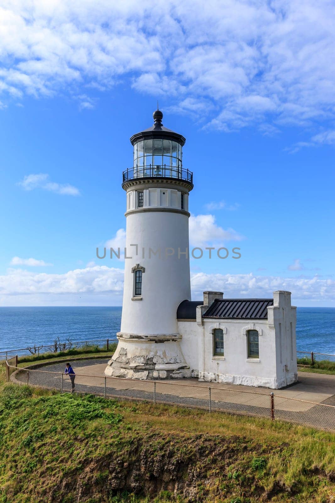 A female tourist stands by the North Head lighthouse in Ilwaco, Washington.
