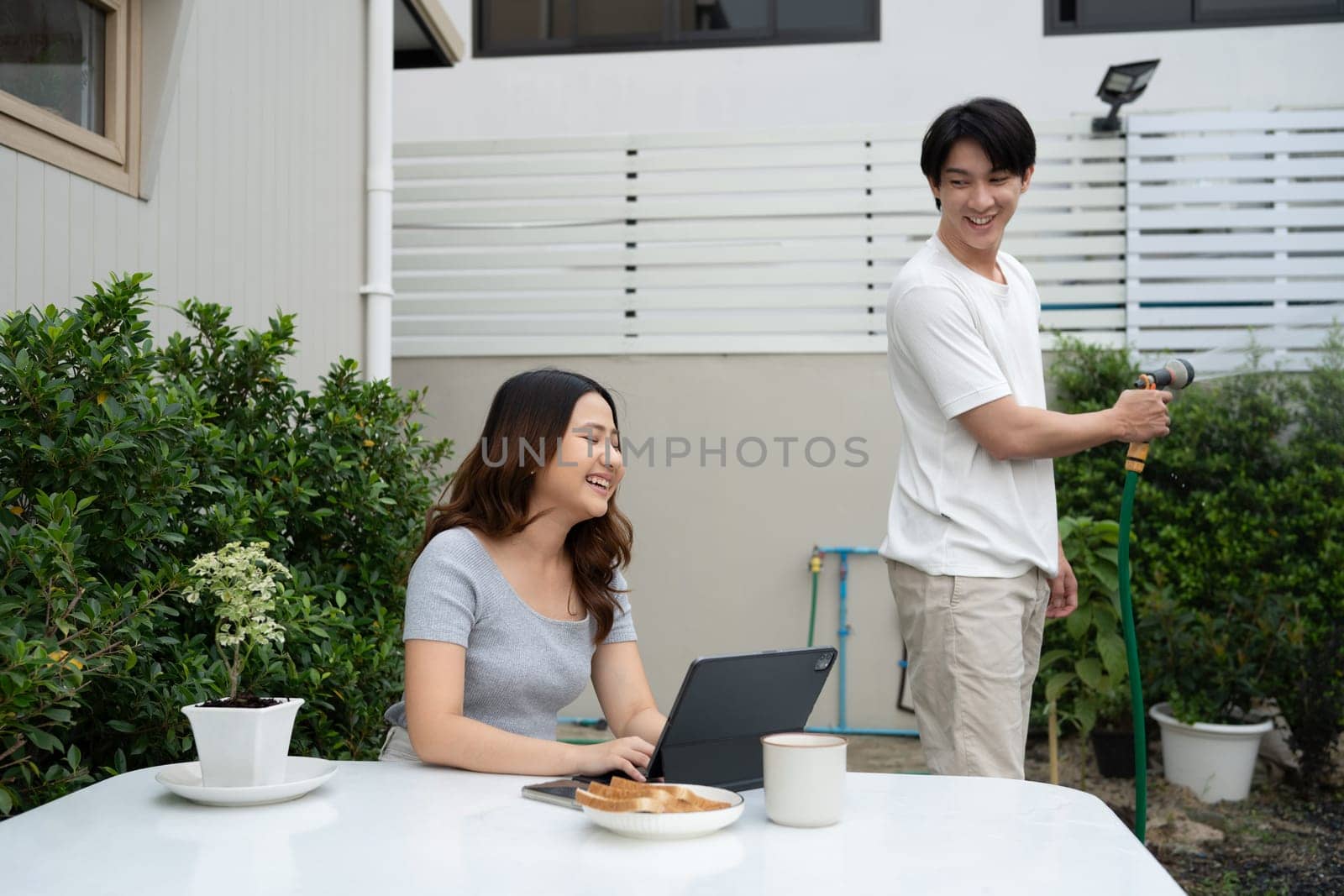 Happy asian couple spending quality time together in cozy backyard.