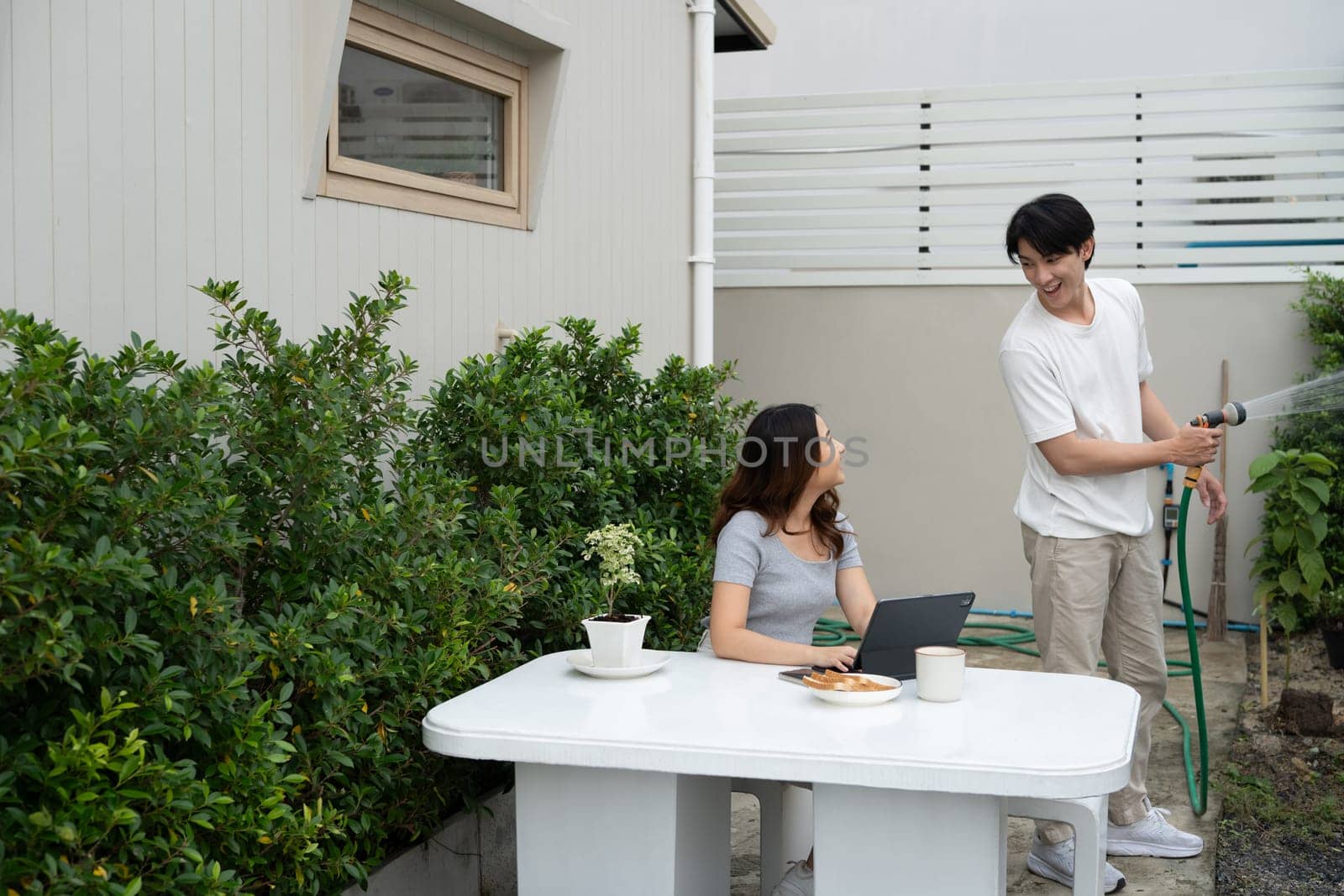 Happy asian couple spending quality time together in cozy backyard.