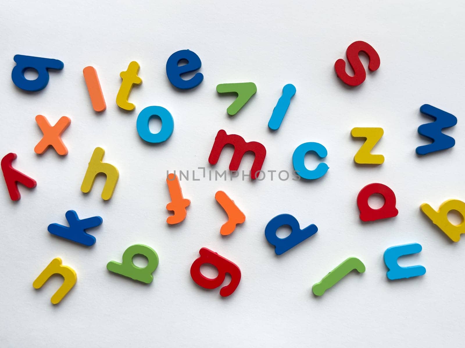 Colorful wooden letters on white background.