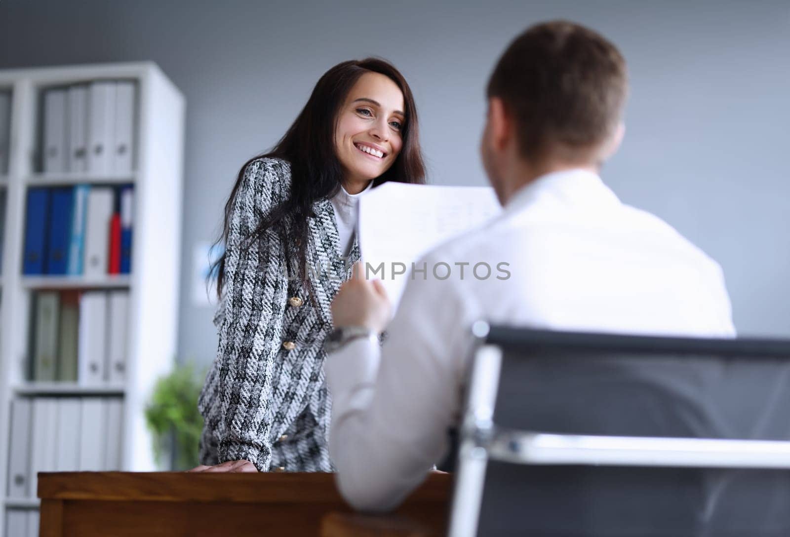 Portrait of cheerful smart businesswoman listening co-workers monthly report. Smiling female in presentable suit in company office. Finance and economy concept