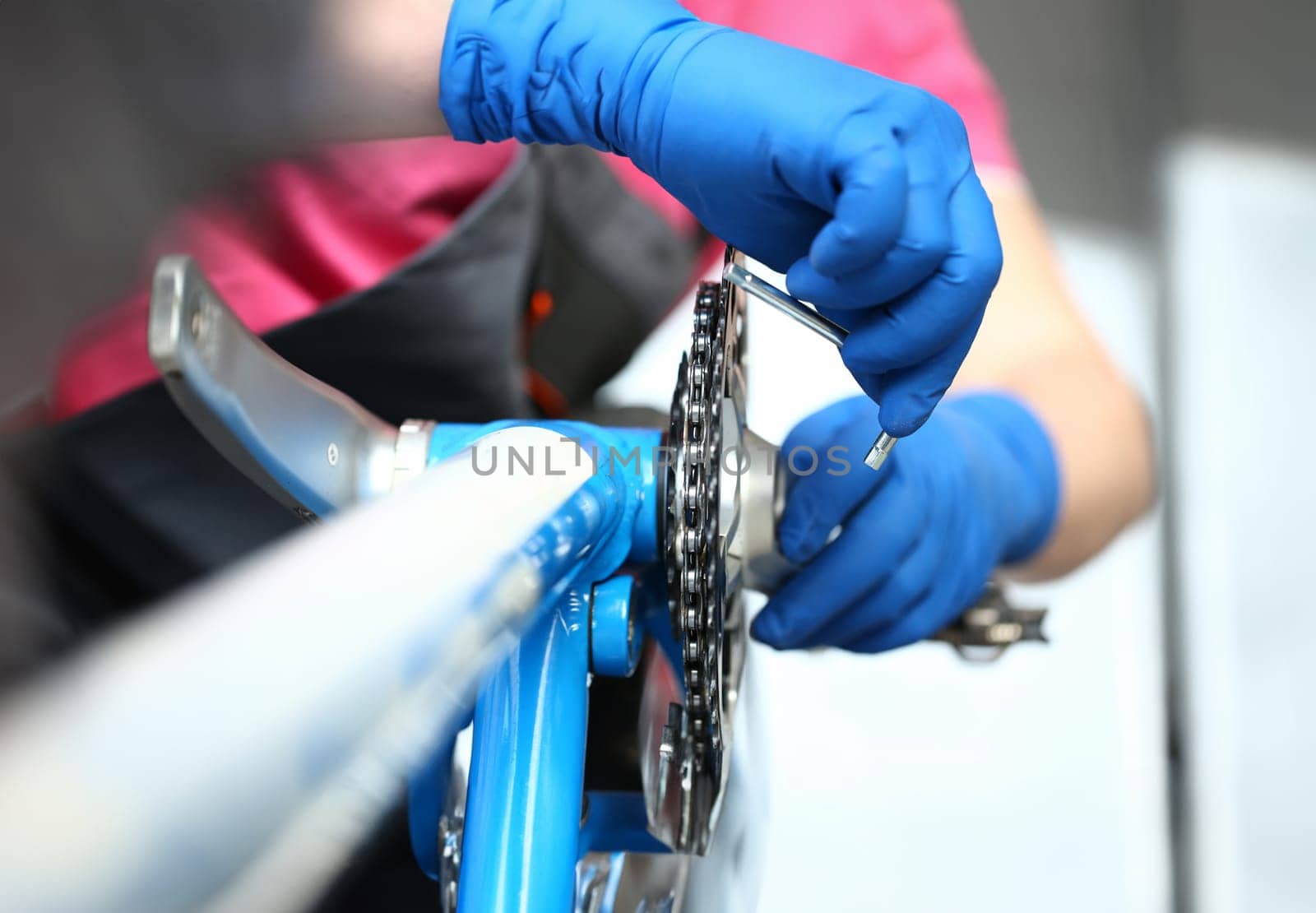 Close-up of mechanic serviceman installing assembling or adjusting bicycle gear on wheel in workshop. Technical expertise. Bike maintenance and repair service concept