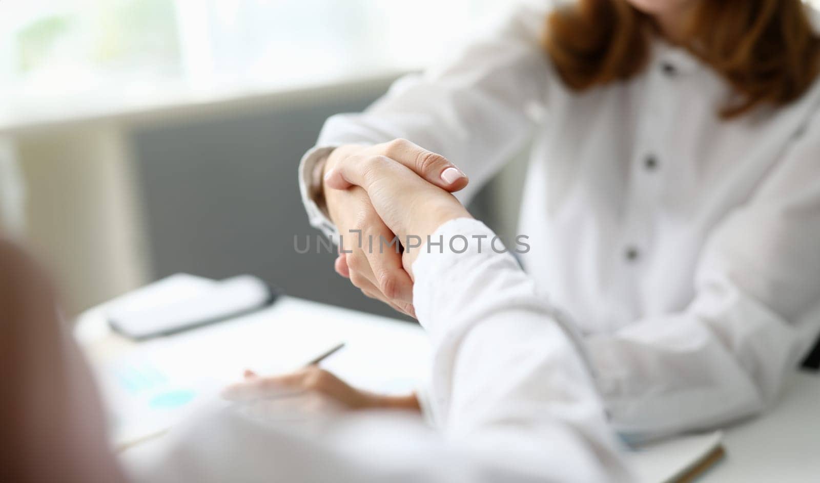 Focus on smart businesswoman arm. Hand of female worker performing friendly gesture to show mutual professional affection. Accounting office concept. Blurred background